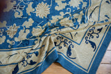 Antique Peking rug corner displaying blue and ivory cloudband, rhinoceros horn, and lotus motifs.