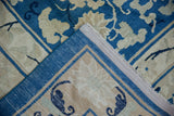 Corner view of an antique Peking rug, revealing cobalt blue pile, beige vinery, and woven foundation.