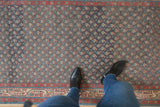 Overhead view of a vintage Serbend runner's repeating boteh pattern and distressed, low-pile texture.