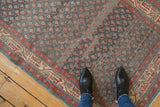 Detailed view of a Persian Serbend runner's worn texture, showing abrashes and staggered boteh motifs.