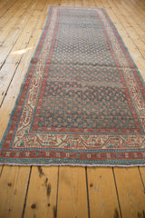 Angled view of a distressed Serbend runner highlighting its repeating boteh field and vine border.