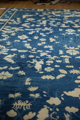 Antique Peking carpet's ivory butterflies and flowing vinery on cobalt blue pile, with mostly even wear.
