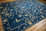 Antique Peking carpet, indigo blue field, ivory blossoms, vinery, and geometric border.