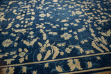 Ivory blossoms and interconnected vinery on the tone-on-tone indigo field of an Antique Peking carpet.
