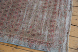 Distressed vintage Malayer rug runner corner showing blush botehs, visible foundation, and blue side selvage.