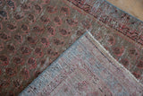 Distressed Malayer rug corner, showing foundation through worn boteh pile and hand-knotted back.