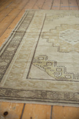 Distressed beige and ecru tones on the corner spandrel and banded Oushak rug border.