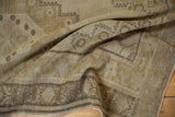 Muted beige and ecru distressed surface of a vintage Oushak rug with geometric border.