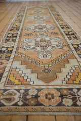 Distressed Oushak runner detail with geometric gold, ivory, charcoal patterns and abrashed ground.