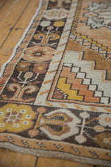 Distressed Oushak runner showing soft saffron, ivory, charcoal patterns and worn texture.