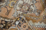 Folded vintage distressed Oushak rug showing abrashed ground, gold, ivory, charcoal patterns.