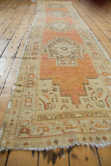 Close-up of distressed Oushak runner side, showing stepped geometric pattern, terra cotta, ivory, and faint wear.