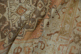 Close-up of folded vintage Oushak runner, geometric patterns in terra cotta, sandalwood, and beige.