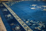 Densely ornamented ivory and blue floral vine border of a vintage Peking carpet.