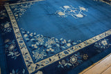 Vintage Peking carpet corner with indigo blue field and densely ornamented floral spandrels.