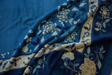 Curving ivory blossoms on indigo and powder blue tones of a vintage Peking carpet.