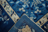 Folded corner of vintage Peking rug revealing indigo blue floral pile and woven foundation.