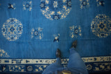 Vintage Peking carpet's sky blue field, ivory medallions, floral motifs, and pictorial border.