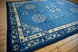 Corner view of a vintage Chinese Peking carpet, highlighting pictorial floral and vine borders.