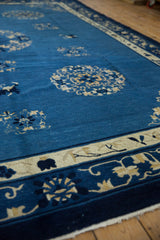 Denim blue vintage Peking rug showing intact side cord and ivory border with floral motifs.