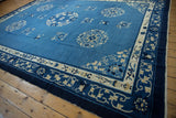 Corner of a vintage Chinese Peking rug with indigo blue curvilinear border and natural fringe.