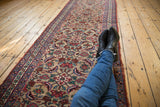 A long view of an antique Bijar runner's repeating allover pattern of interlaced floral vinery.