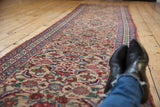Perspective view down the antique Bijar runner, showing its full length and interlaced vinery.