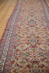 A long view down an antique Bijar runner showcasing the repeating allover floral and leaf motif.