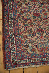 Worn corner of an antique Bijar runner, detailing the intricate floral borders and tattered side selvage.
