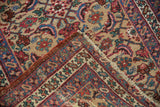 Folded corner of an antique Bijar runner revealing the hand-knotted back and timeworn side cord.
