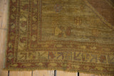 Vintage distressed Oushak rug corner shows knot head wear, exposed foundation, and fringe.