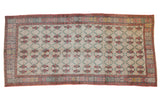 Vintage Oushak runner with a distressed floral lattice pattern in red, green, and slate.