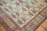 Corner view of a vintage Oushak's low pile, showing the floral border and lattice pattern field.