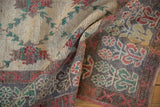 Textured wool pile and floral motifs on the oxidized silver border of a draped vintage Oushak.