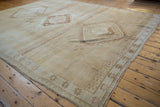 Distressed vintage Oushak rug with a diamond medallion and geometric border in beige and coffee brown.