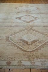 Distressed pile texture revealing geometric stepped patterns on a vintage Oushak rug.