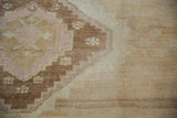 Textured pile detail showing geometric brown, blush pink, and ivory stepped motifs.