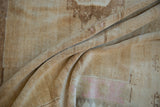 Distressed vintage Oushak carpet pile featuring soft beige, sand, and faded pink tones.