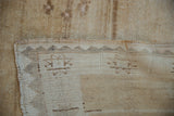 Distressed Oushak carpet edge revealing short pile and hand knotted foundation.