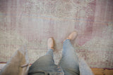 Distressed vintage Sparta carpet with worn texture, revealing knot heads and muted floral design.