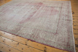 Distressed vintage Sparta carpet with visible wear across faded raspberry red and ivory pile.
