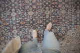 Distressed vintage Sparta carpet featuring worn floral arabesque pattern in oxidized silver, rust, and charcoal.
