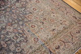 Distressed Sparta rug with faded floral arabesque, rust blossoms, and charcoal border.