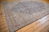 Corner of distressed Sparta carpet, showcasing faded floral arabesque with beige and rust patina.