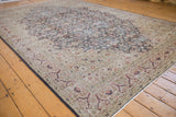 Distressed vintage Sparta carpet corner, beige floral border with rust accents and short fringe.