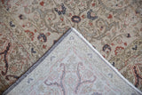 Distressed vintage Sparta carpet showing worn beige floral arabesque and hand-knotted foundation.