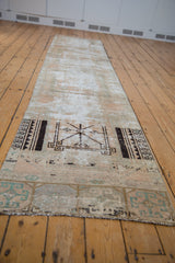 Distressed Oushak runner end with bold charcoal geometric motif against worn blush-silver foundation.