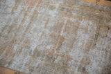 Distressed Oushak rug runner texture, showing exposed foundation and soft silver, blush tones.