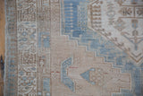 Stepped geometric patterns in pale blue and sand tones on a distressed Serab runner.