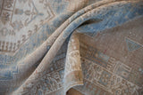 Distressed Serab runner texture: faded blue-beige geometric motifs and visible foundation.